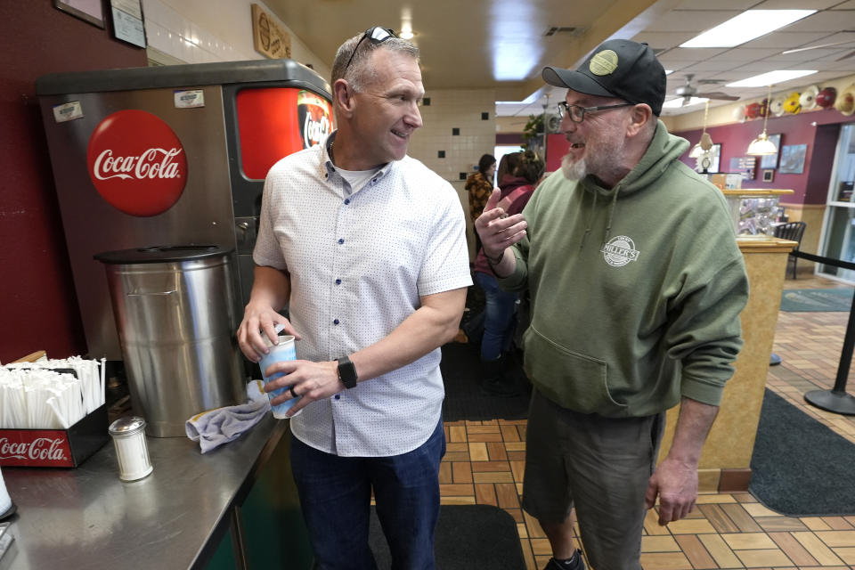 Shasta County First District Supervisor Kevin Crye right talks with Jason Miller, owner of "Lucky MIller's Deli, and is a supporter of Crye, in Redding, Calif., Wednesday, Feb. 21, 2024. Crye is one of the board members who voted to get rid of the county's ballot-counting machines in favor of counting ballots by hand. Miller, a supporter of Crye's said that after he posted a Facebook complaint about crime near his deli, Crye contacted him and brought the issue up with police. (AP Photo/Rich Pedroncelli)