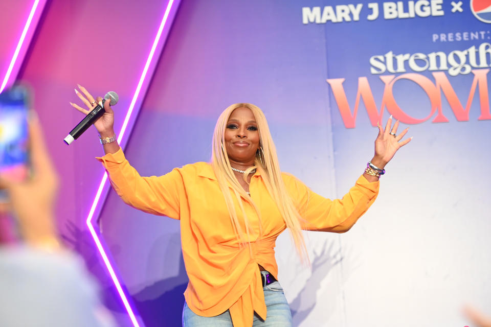 Mary J. Blige holding hands up.