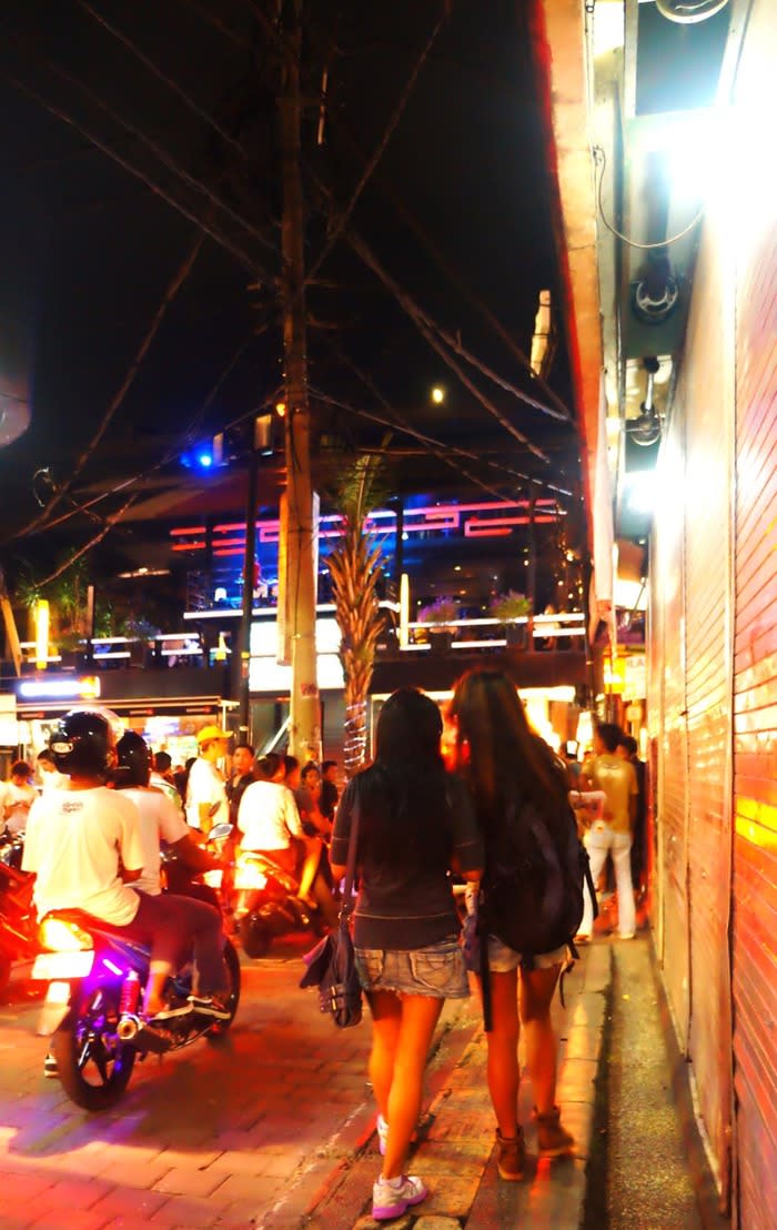 Road to party: People entering the party-ridden Legian Street from the iconic backpacker's heaven, the Poppies lane. The Poppies that is filled with low-budget hotels is the perfect match for the low-budget party center of Legian. (