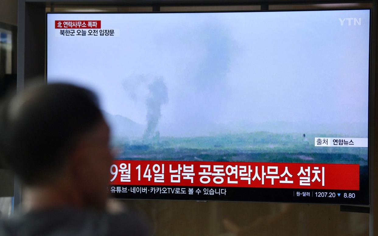 People watch a television news screen showing an explosion of an inter-Korean liaison office in North Korea's Kaesong Industrial Complex - AFP