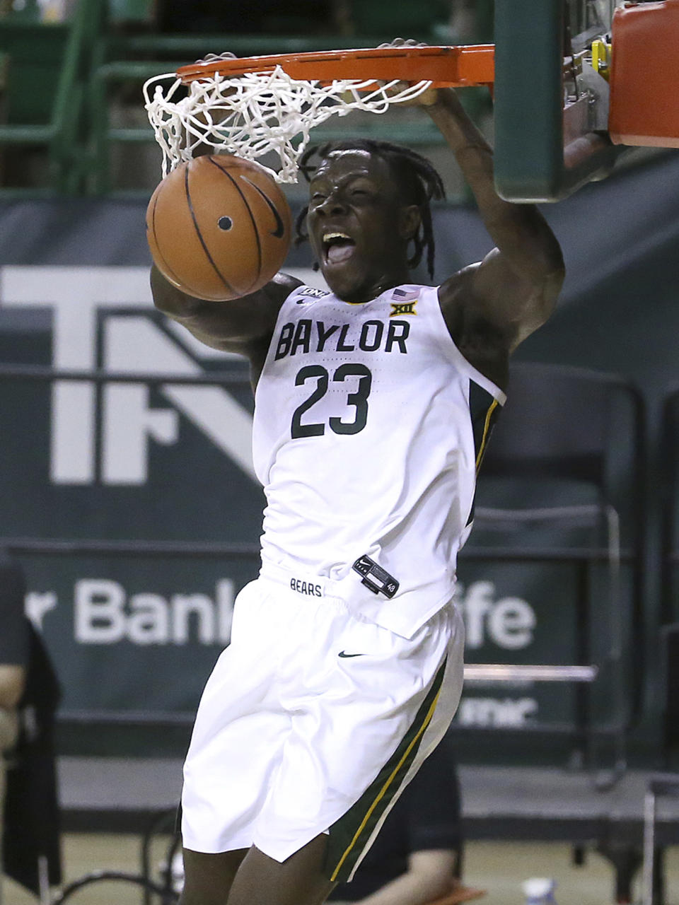 FILE - In this file photo dated Tuesday, Dec. 29, 2020, Baylor forward Jonathan Tchamwa Tchatchoua (23) dunks the ball against Central Arkansas in the first half of an NCAA college basketball game, in Waco, Texas, USA. The NBA's global academy system is beginning to produce high-level collegiate players, as the upcoming NCAA Tournament will include eight NBA Academy alumni. (AP Photo/ Jerry Larson, FILE)