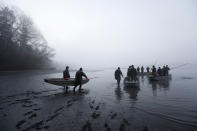 In this picture taken on Thursday, Nov. 15, 2018, fishermen carry a boat during the traditional fish haul of the Krcin pond near the village of Mazelov, Czech Republic. Czechs will have to pay more for their traditional Christmas delicacy this year after a serious drought devastated the carp population this year. (AP Photo/Petr David Josek)