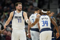Dallas Mavericks guard Luka Doncic (77) high-fives guard Kemba Walker (34) during the first half of an NBA basketball game against the Minnesota Timberwolves, Wednesday, Dec. 21, 2022, in Minneapolis. (AP Photo/Abbie Parr)