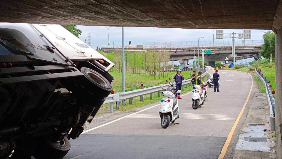 一輛貨車誤闖機車道慘卡涵洞「翹孤輪」。取自記者爆料網。