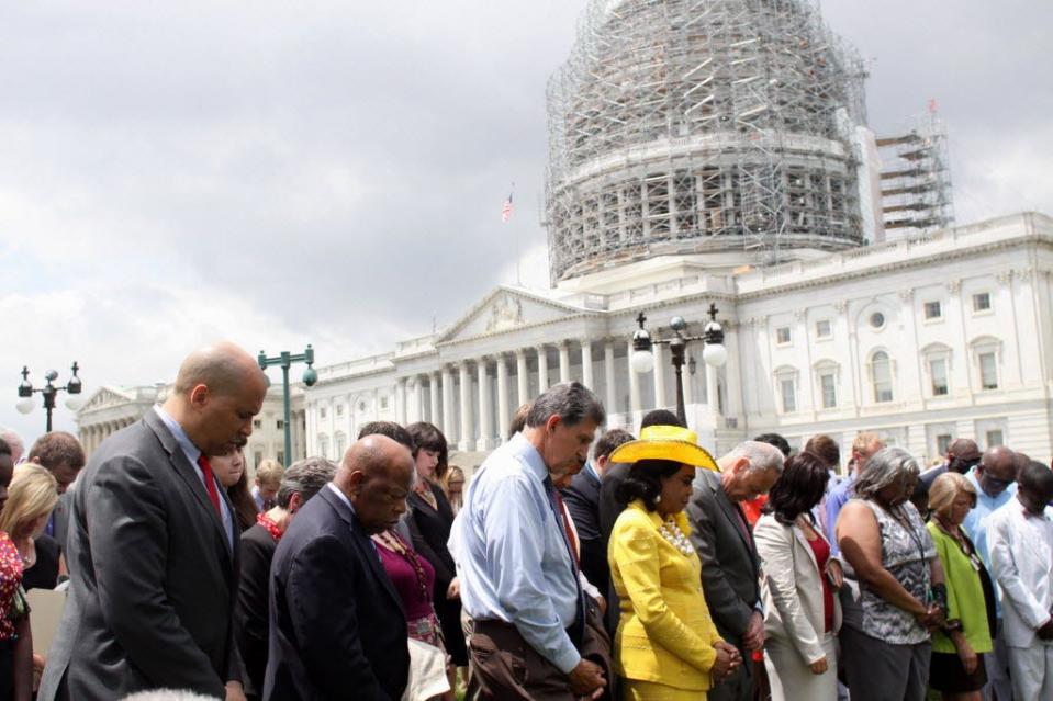 From left, Sen. Cory Booker, D-N.J., Rep. John Lewis, D-Ga., Sen. Joe Manchin, D-W.Va., Rep. Frederica Wilson, D-Fla., Sen. Charles Schumer, D-N.Y., and others gather on Capitol Hill on June 18, 2015, in prayer to mourn the shooting victims of Emanuel AME Church in Charleston, S.C.