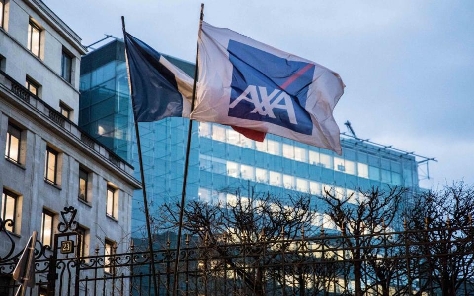 A French national flag and a flag displaying the AXA SA logo fly outside the insurance company's headquarters in Paris, France - Christophe Morin/Bloomberg