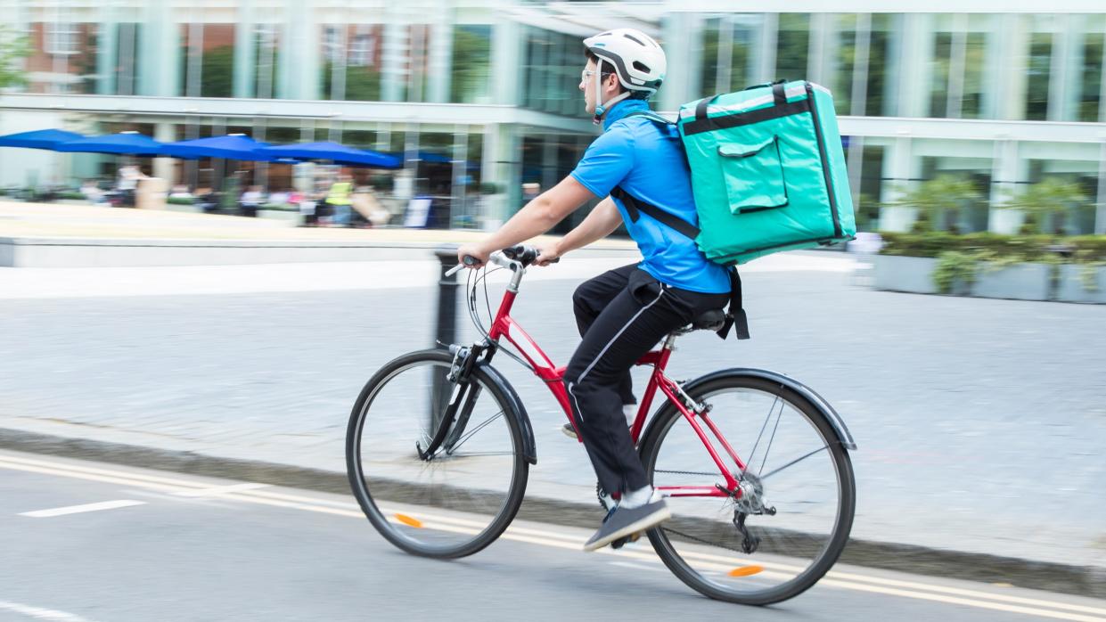  Courier On Bicycle Delivering Food In City . 