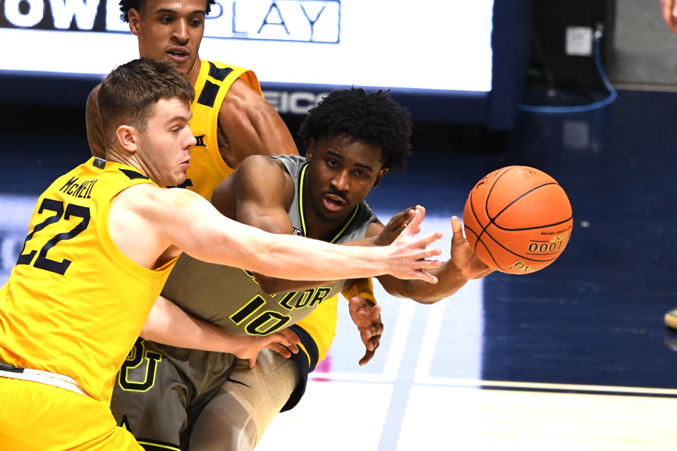 Adam Flagler #10 of the Baylor Bears passes the ball around Sean McNeil #22 of the West Virginia Mountaineers in the second half during a college basketball game at WVU Coliseum  on March 2, 2021 in Morgantown, West Virginia.  (Photo by Mitchell Layton/Getty Images)