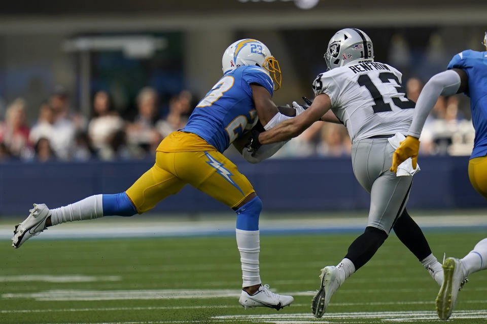 Los Angeles Chargers cornerback Bryce Callahan, left, intercepts a pass in front of Las Vegas Raiders wide receiver Hunter Renfrow (13) during the second half of an NFL football game in Inglewood, Calif., Sunday, Sept. 11, 2022. (AP Photo/Gregory Bull)