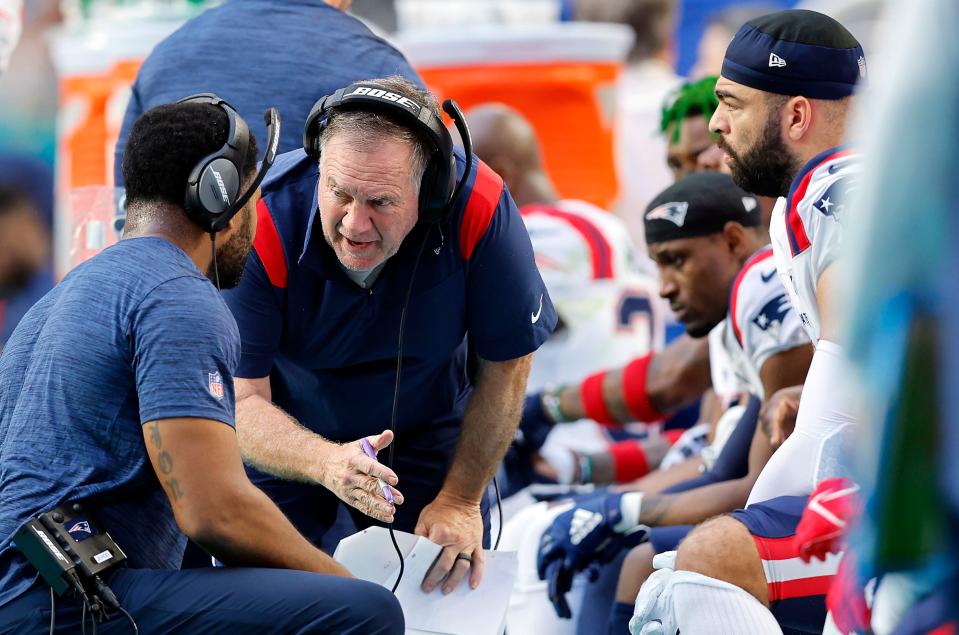 MIAMI GARDENS, FLORIDA - JANUARY 09: Head coach Bill Belichick of the New England Patriots and inside linebackers coach Jerod Mayo talk on the sidelines in the first quarter of the game against the Miami Dolphins at Hard Rock Stadium on January 09, 2022 in Miami Gardens, Florida. (Photo by Michael Reaves/Getty Images)