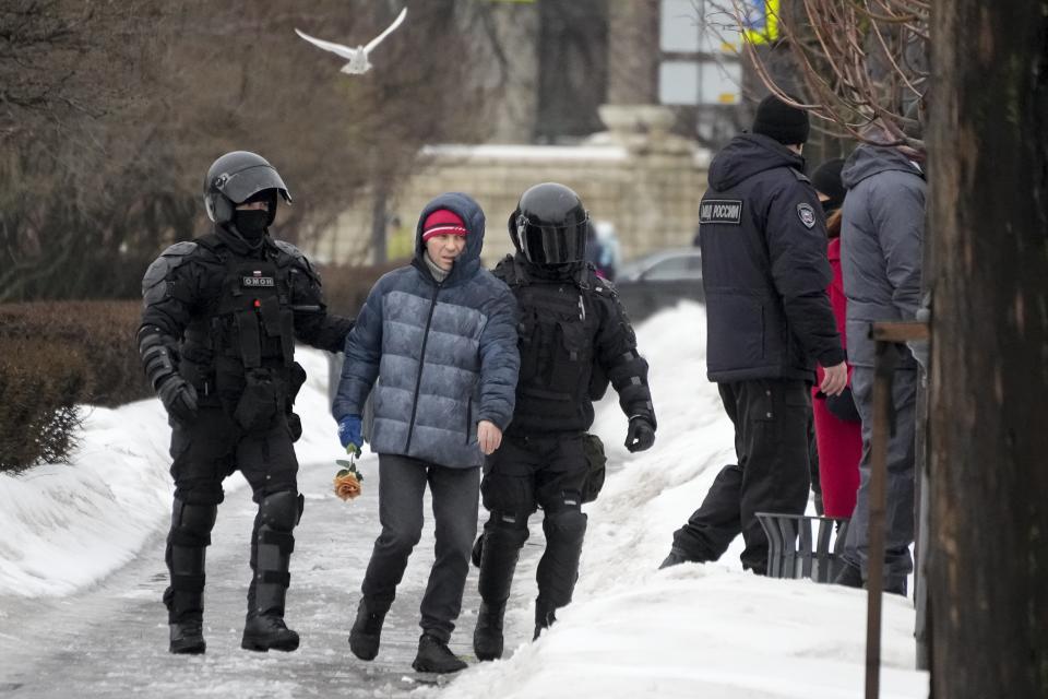 Police detain a man as he wanted to lay flowers paying their last respect to Alexei Navalny at the monument, a large boulder from the Solovetsky islands, where the first camp of the Gulag political prison system was established, in St. Petersburg, Russia on Saturday, Feb. 17, 2024. Russian authorities say that Alexei Navalny, the fiercest foe of Russian President Vladimir Putin who crusaded against official corruption and staged massive anti-Kremlin protests, died in prison. He was 47. (AP Photo/Dmitri Lovetsky)
