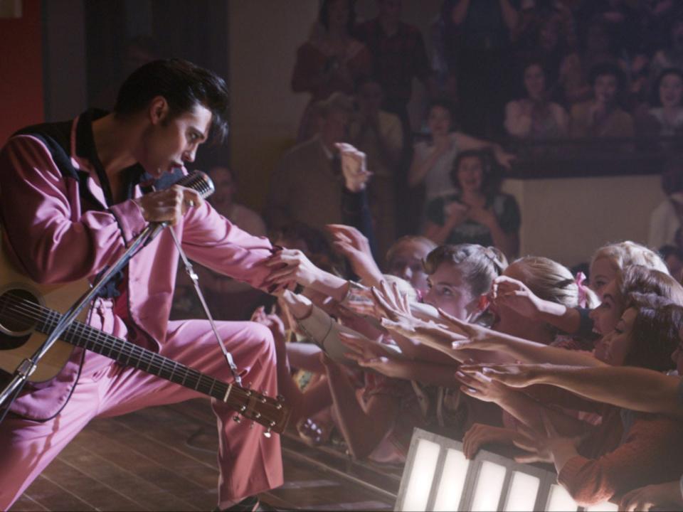 Austin Butler as Elvis on stage as fans try to touch him