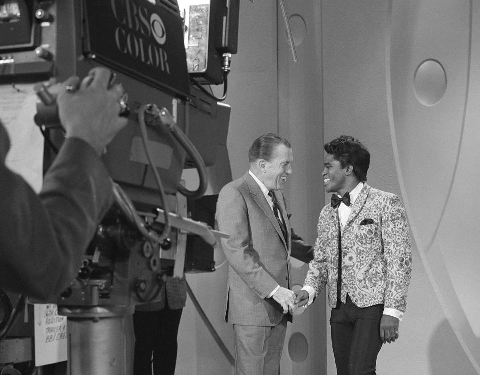 TV host Ed Sullivan shakes hands with soul singer James Brown on the set of 