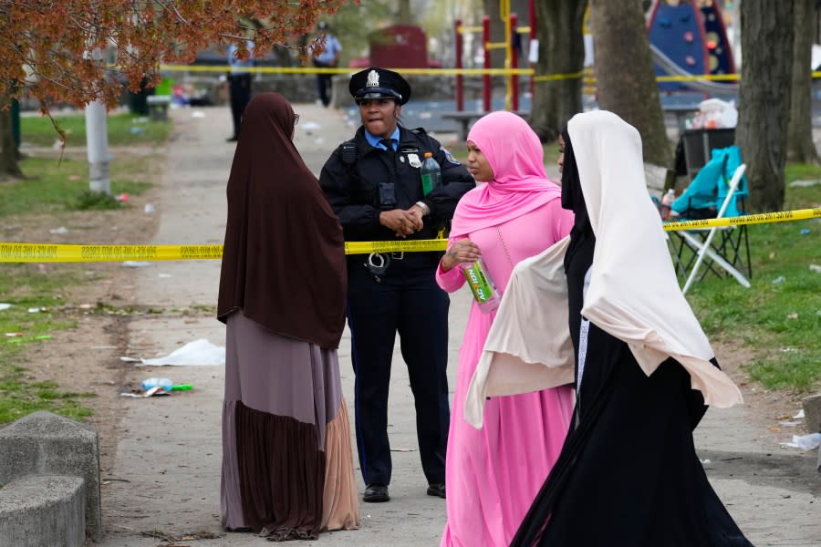 A person talks to an officer in the aftermath of a shooting at an Eid al-Fitr event in Philadelphia, Wednesday, April 10, 2024. (AP Photo/Matt Rourke)