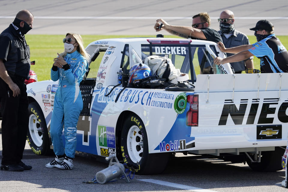 Driver Natalie Decker, second from left, waits for the start of a NASCAR Truck Series auto race at Kansas Speedway in Kansas City, Kan., Friday, July 24, 2020. (AP Photo/Charlie Riedel)