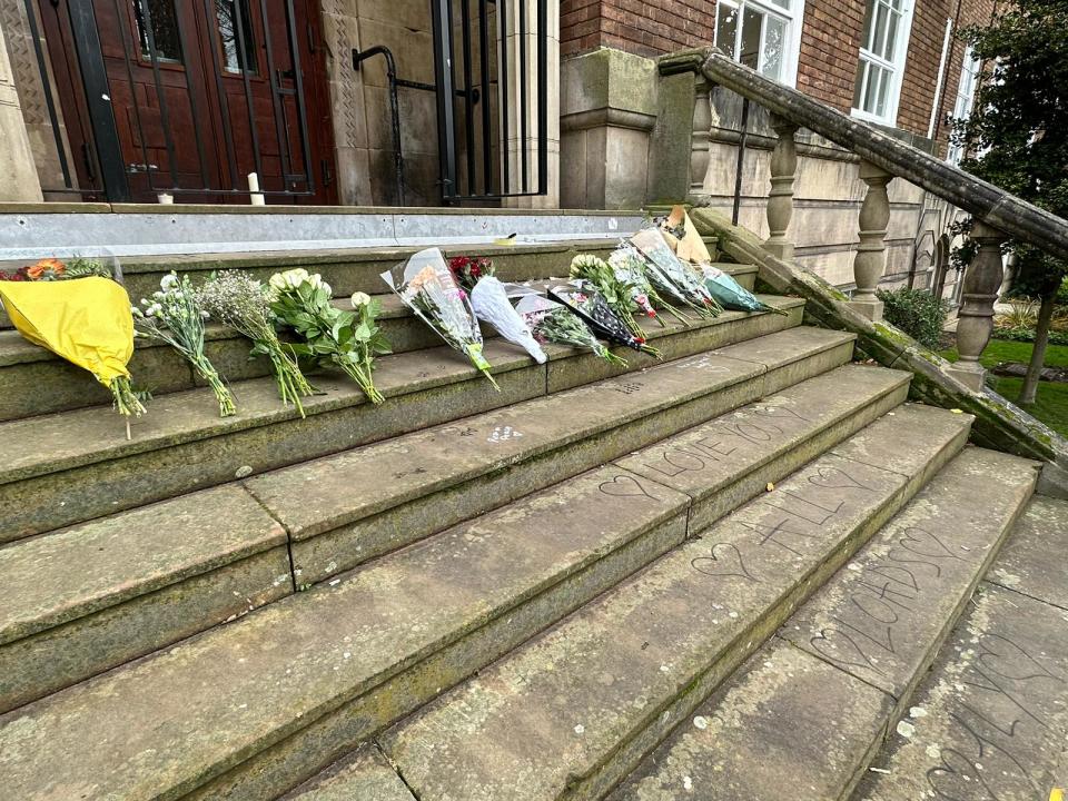 Along with flowers, a handwritten note has also been left by students in tribute to the four young men (The Independent)