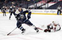 Columbus Blue Jackets forward Jack Roslovic, left, controls the puck against Chicago Blackhawks defenseman Connor Murphy during the second period of an NHL hockey game in Columbus, Ohio, Monday, April 12, 2021. (AP Photo/Paul Vernon)