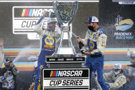 Chase Elliott, left, and pit crew chief Alan Gustafson celebrate their season championship in Victory Lane after winning a NASCAR Cup Series auto race at Phoenix Raceway, Sunday, Nov. 8, 2020, in Avondale, Ariz. (AP Photo/Ralph Freso)