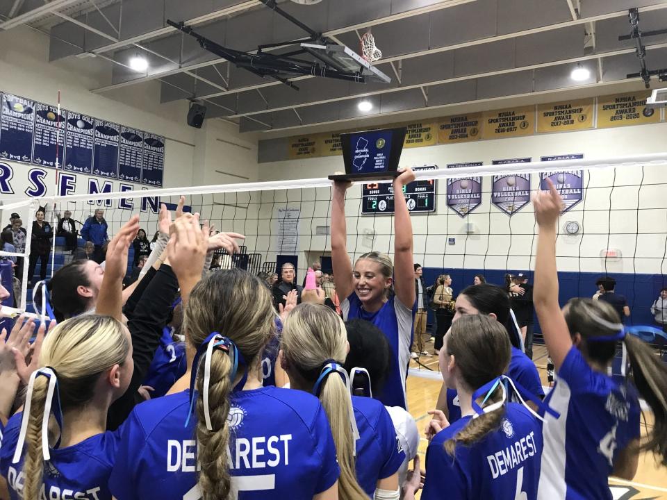Taylor Miller holds up the trophy after Demarest won the North 1, Group 2 girls volleyball championship on Tuesday, Nov. 7, 2023.