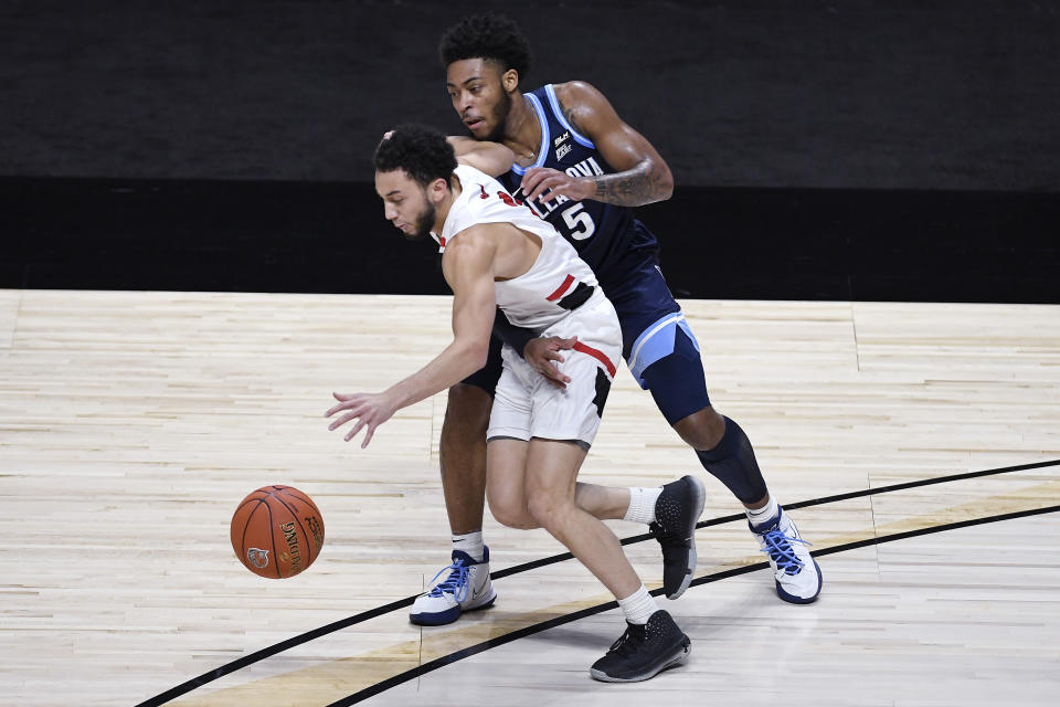 Hartford's D.J. Mitchell dribbles the ball under pressure from Villanova's Justin Moore, right, in the first half of an NCAA college basketball game, Tuesday, Dec. 1, 2020, in Uncasville, Conn. (AP Photo/Jessica Hill)