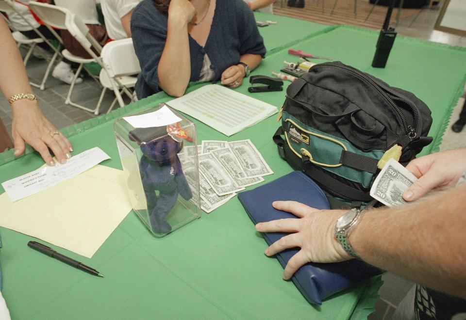 A successful bidder pays two hundred dollars for a Princess Beanie Baby, honoring Princess Diana, during a Beanie Baby auction at a mall in Cerritos, Calif., Thursday, July 23, 1998.