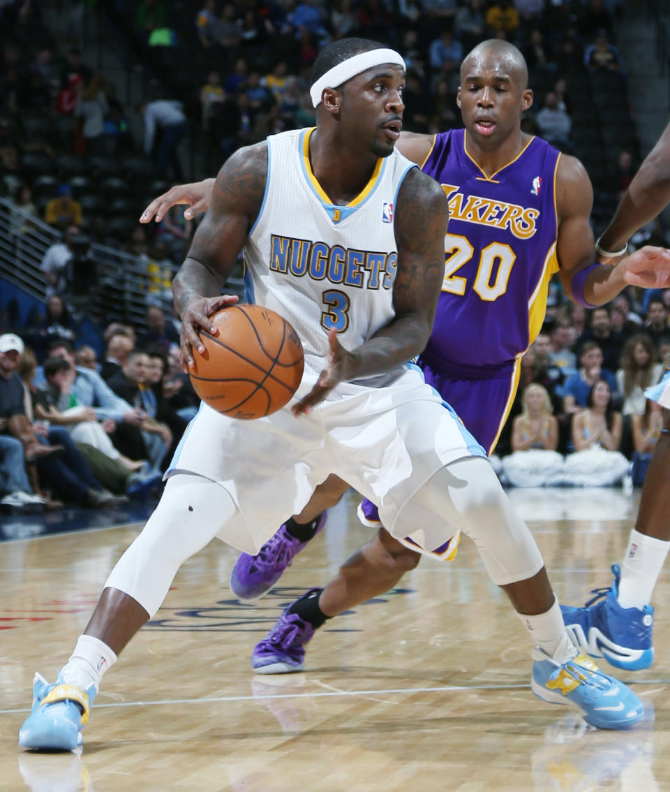 Denver Nuggets guard Ty Lawson, front, looks to pass ball as Los Angeles Lakers guard Jodie Meeks covers in the fourth quarter of the Nuggets' 134-126 victory in an NBA basketball game in Denver on Friday, March 7, 2014. (AP Photo/David Zalubowski)