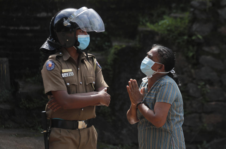 A family member of an inmate pleads to a policeman as she seeks information on the condition of her relative outside the Mahara prison complex following an overnight unrest in Mahara, outskirts of Colombo, Sri Lanka, Monday, Nov. 30, 2020. Sri Lankan officials say six inmates were killed and 35 others were injured when guards opened fire to control a riot at a prison on the outskirts of the capital. Two guards were critically injured. Pandemic-related unrest has been growing in Sri Lanka's overcrowded prisons. (AP Photo/Eranga Jayawardena)