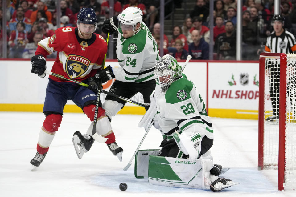 Dallas Stars center Roope Hintz (24) and goaltender Jake Oettinger (29) defend the goal against Florida Panthers center Sam Bennett (9) during the second period of an NHL hockey game, Wednesday, Dec. 6, 2023, in Sunrise, Fla. (AP Photo/Lynne Sladky)