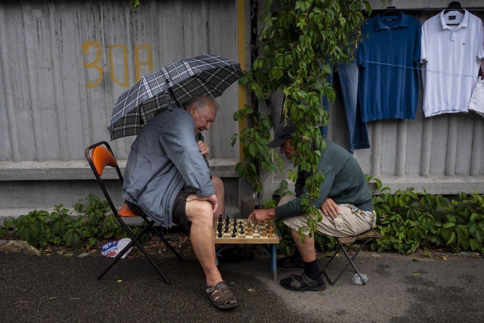 Dos vendedores juegan al ajedrez en un mercadillo callejero en Kiev, Ucrania, el 8 de julio de 2023. El vecindario de Pochaina de la capital ucraniana cobra vida cada fin de semana cuando cientos de personas acuden en masa a su famoso mercadillo en busca de tesoros. (AP Foto/Jae C. Hong)