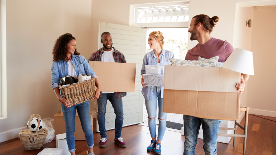 Friends help a couple carry moving boxes. - Monkey Business/iStockphoto