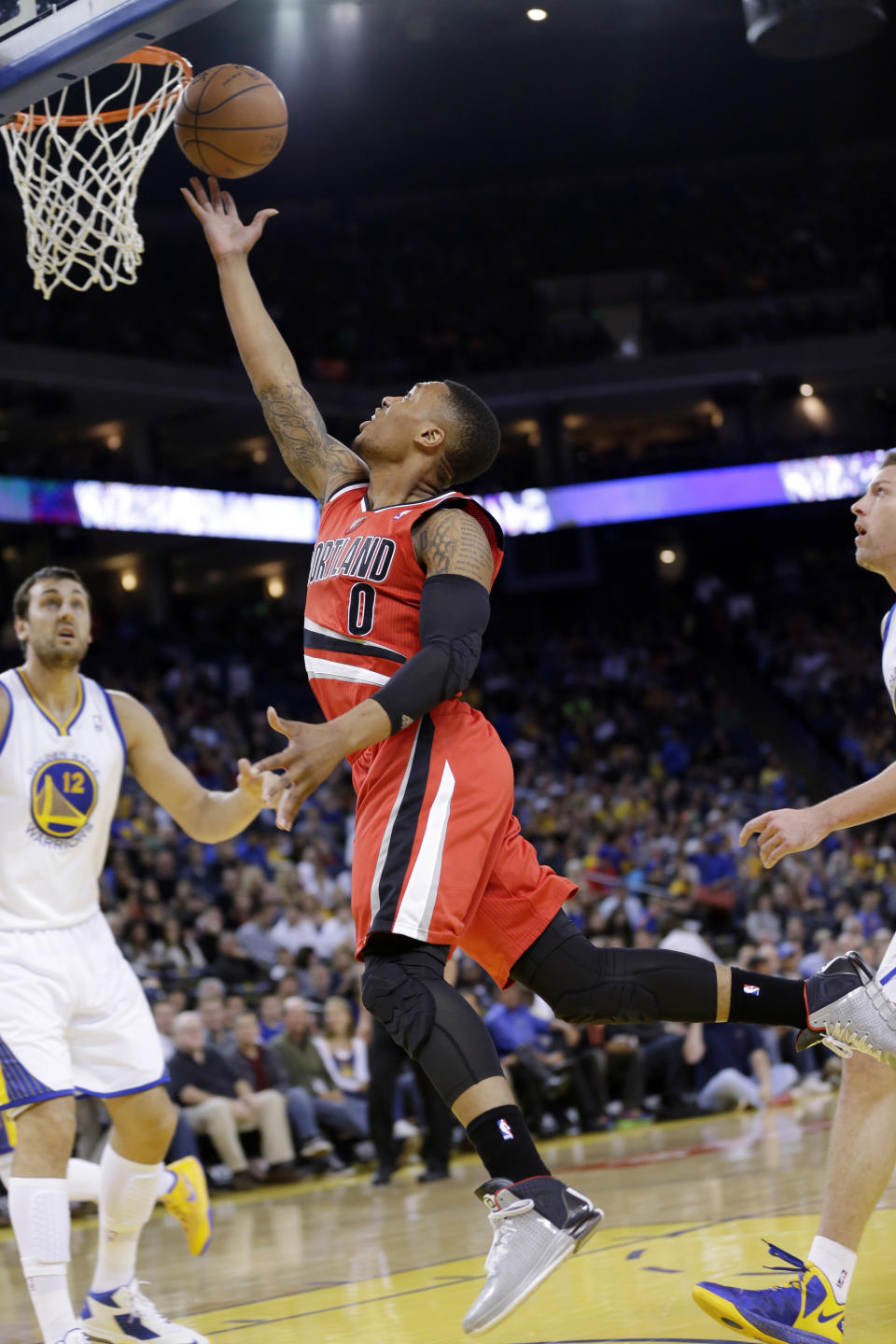 Damian Lillard (0), de los Trail Blazers de Portland, encesta en duelo ante los Warriors de Golden State el domingo 26 de enero de 2014, en Oakland, California. Lillard fue elegido suplente para el Juego de Estrellas, junto con su compañero en Trail Blazers LaMarcus Aldridge, el jueves 30 de enero. (Foto AP/Marcio José Sánchez)