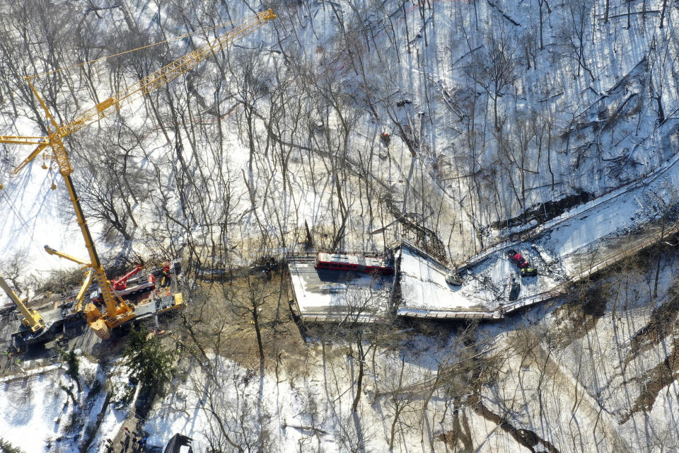 A crane is in place on Monday, Jan. 31, 2022, as part of clean up efforts at the Fern Hollow Bridge in Pittsburgh that collapsed Friday, Jan. 28. (AP Photo/Gene J. Puskar)