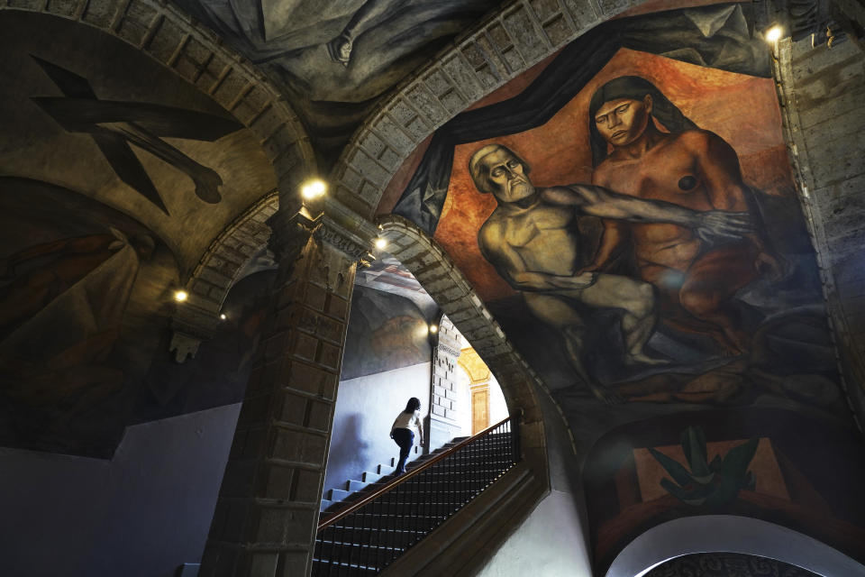 A mural by Jose Clemente Orozco, titled "Cortes and La Malinche" adorns a ceiling inside the former Jesuit college Antiguo Colegio de San Ildefonso in Mexico City, Wednesday, April 26, 2023. The historian of San Ildefonso said that muralism arose in a highly politicized context. Most of the wall paintings at San Ildefonso criticize politics, inequality or the church. (AP Photo/Marco Ugarte)