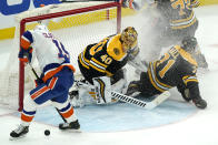 New York Islanders right wing Cal Clutterbuck, left, can't control the puck to get a shot off as Boston Bruins goaltender Tuukka Rask, center, and Bruins left wing Taylor Hall, right, protect the goal after a flurry in the first period of an NHL hockey game, Monday, May 10, 2021, in Boston. (AP Photo/Elise Amendola)