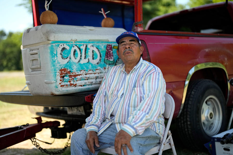 Andres Matamoros sits in the shade as he tries to keep cool while selling fresh fruit and cold coconuts in Houston on June 28, 2023.  (David J. Phillip / AP)