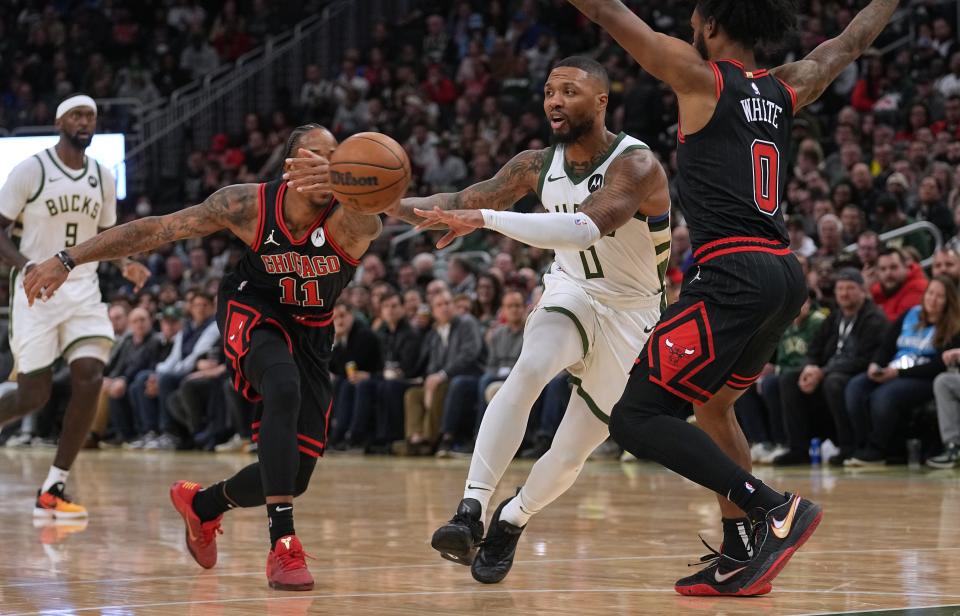 Bucks guard Damian Lillard passes the ball to guard Malik Beasley who hit a three-point basket during the first half Monday. Lillard had missed two games with right calf soreness.