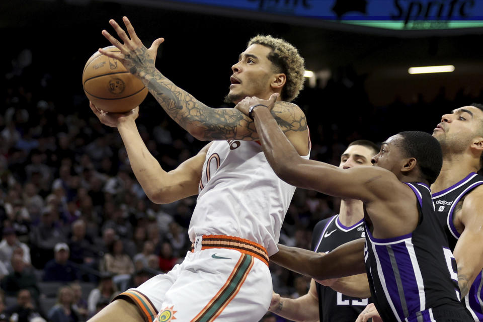 San Antonio Spurs forward Julian Champagnie shoots against Sacramento Kings guard De'Aaron Fox, right front, during the second half of an NBA basketball game Thursday, March 7, 2024, in Sacramento, Calif. (AP Photo/Jed Jacobsohn)