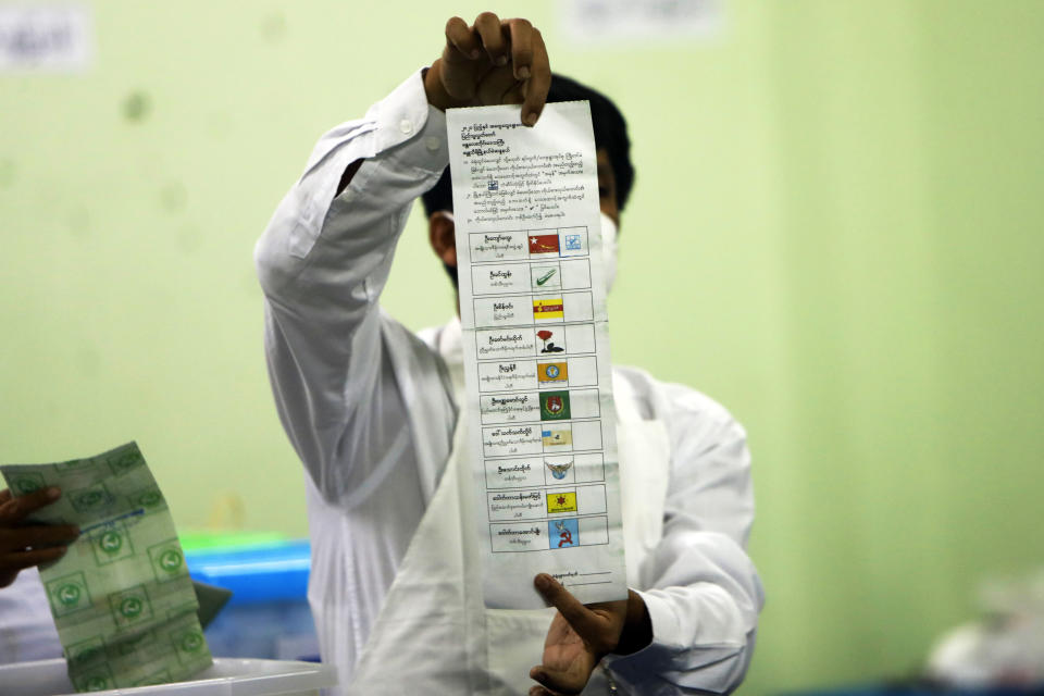 FILE - In this Sunday, Nov. 8, 2020 file photo, an official of the Union Election Commission counts ballots at a polling station in Naypyitaw, Myanmar. On Friday, Feb. 5, 2021, The Associated Press reported on stories circulating online incorrectly asserting Myanmar used the election technology firm Dominion Voting Systems for its recent elections. The country used paper ballots _ not machines _ to vote in its November 2020 election. (AP Photo/Aung Shine Oo)