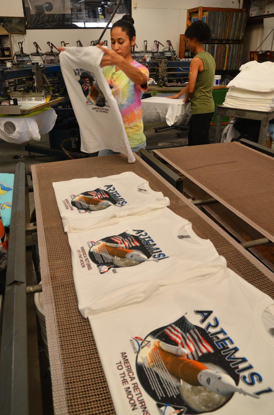 Sisters Rosa and Nancy Ross crank out Artemis I T-shirts on the press Tuesday at Space Shirts on north Merritt Island.