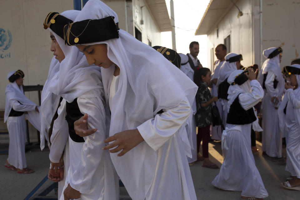 In this Sept. 14, 2019 photo, Yazidi youth, dressed in traditional clothes, take part in a program to reacquaint them with their religion and culture at Khanke IDP Camp, northern Iraq. Some 3,500 Yazidi slaves have been freed from Islamic State militant clutches in recent years, most of them ransomed by their families. But more than 2,900 Yazidis remain unaccounted for, including some 1,300 women and children, according to the Yazidi abductees office in Iraq's Kurdish autonomous region. (AP Photo/Maya Alleruzzo)