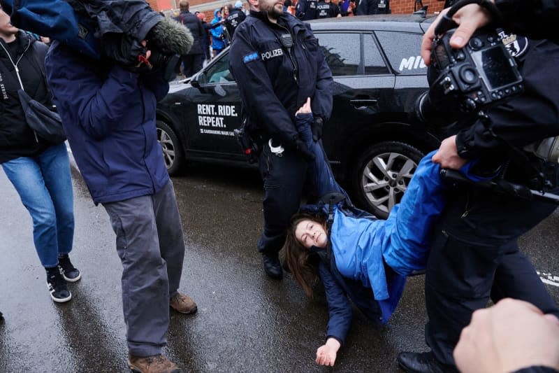 Police officers pull a climate activist off the street during a demonstration by Last Generation with doctors, scientists, craftsmen, students and pensioners take place across Germany. Annette Riedl/dpa