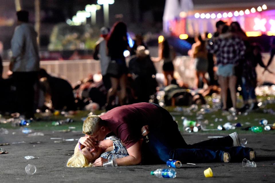 A man shields a woman from the threat of gunfire