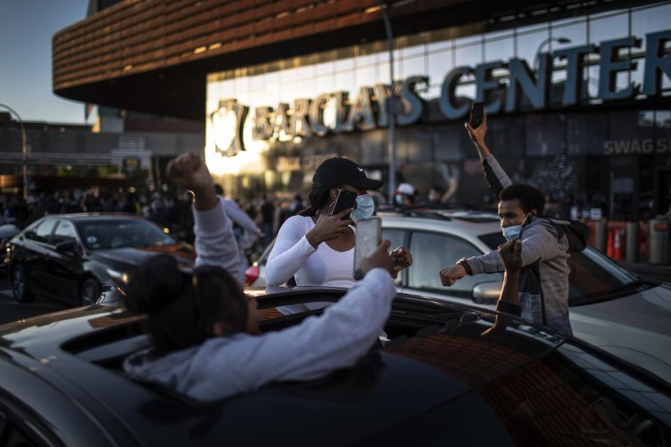 Protesters march down the street while some cheer from out of their cars during a solidarity rally for George Floyd, Sunday, May 31, 2020, in the Brooklyn borough of New York. Protests were held throughout the city over the death of Floyd, a black man in police custody in Minneapolis who died after being restrained by police officers on Memorial Day. (AP Photo/Wong Maye-E)