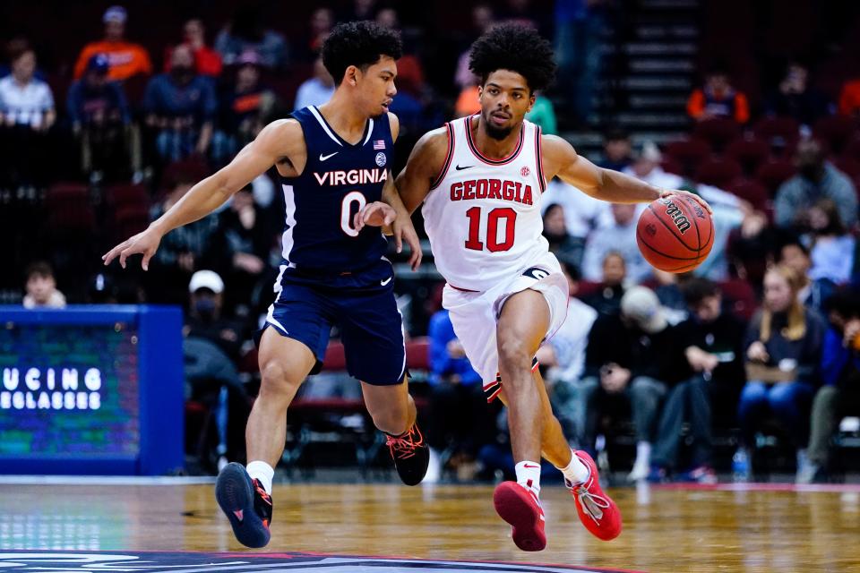 Virginia's Kihei Clark (0) defends against Georgia's Aaron Cook (10) during the second half of an NCAA college basketball game Monday, Nov. 22, 2021, in Newark, N.J. (AP Photo/Frank Franklin II)