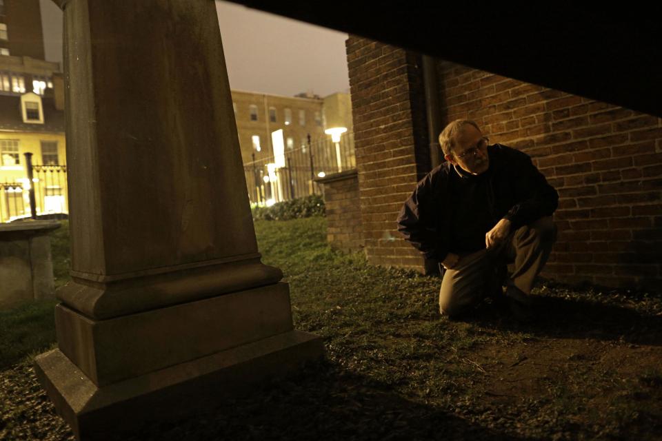 In this Jan. 15, 2013 photo, Jeff Jerome looks through a passage underneath Westminster Hall in Baltimore, where the mysterious Poe Toaster would sometimes slip through on his way to place three roses and an unfinished bottle of cognac upon Edgar Allan Poe's original grave. His identity is a great modern mystery, and just as mysteriously, the tradition ended four years ago. (AP Photo/Patrick Semansky)