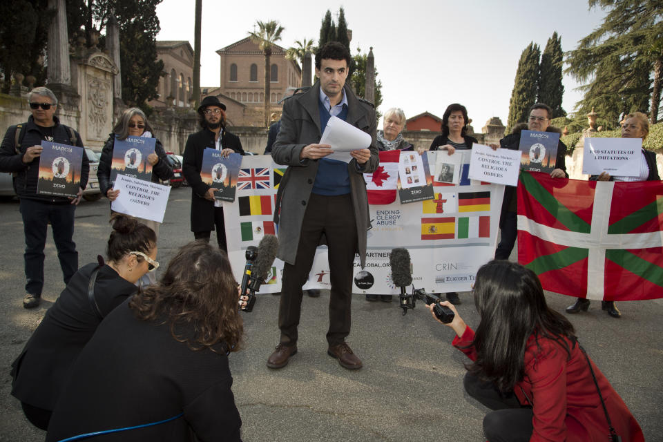 Child psychologist and founding member of the Ending Clergy Abuse (ECA) organization, Miguel Hurtado from Spain, center, reads an open letter to the Benedictine order outside the St. Anselm on the Aventine Benedictine complex in Rome on the second day of a summit called by Pope Francis at the Vatican on sex abuse in the Catholic Church, Friday, Feb. 22, 2019. Pope Francis has issued 21 proposals to stem the clergy sex abuse around the world, calling for specific protocols to handle accusations against bishops and for lay experts to be involved in abuse investigations. (AP Photo/Domenico Stinellis)