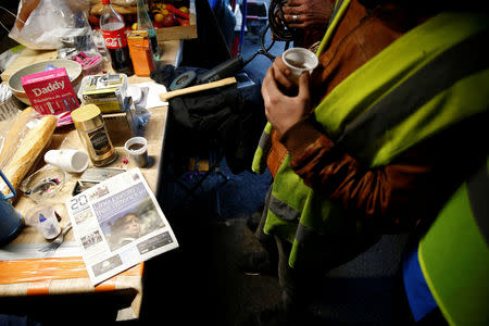 A protester wearing a yellow vest is seen inside a makeshift shelter where they meet and take their meals near the Nantes Atlantique Airport as the "yellow vests" movement continues, in Bouguenais, France, December 10, 2018. REUTERS/Stephane Mahe