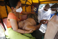 A COVID-19 patient attended inside a vehicle at a dedicated COVID-19 government hospital in Ahmedabad, India, Thursday, April 22, 2021. A fire killed 13 COVID-19 patients in a hospital in western India early Friday as an extreme surge in coronavirus infections leaves the nation short of medical care and oxygen. India reported another global record in daily infections for a second straight day Friday, adding 332,730 new cases. The surge already has driven its fragile health systems to the breaking point with understaffed hospitals overflowing with patients and critically short of supplies. (AP Photo/Ajit Solanki)