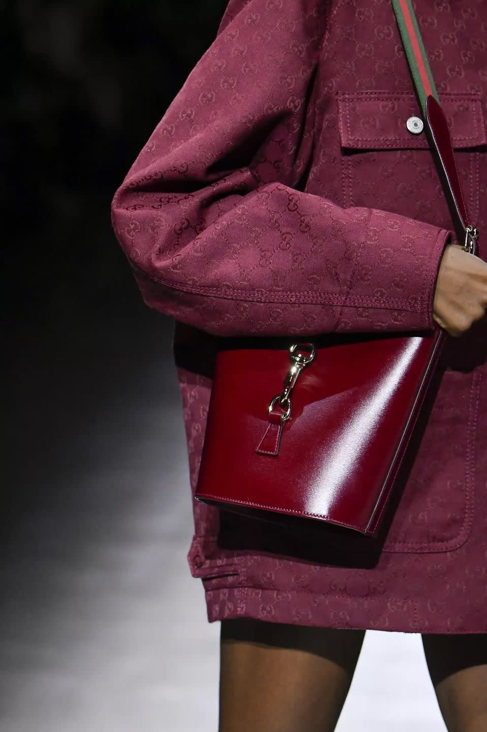 a woman wearing a purple skirt and a pink purse