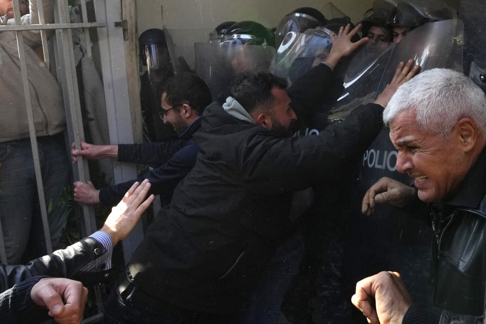 Anti-government protesters scuffle with riot police outside the ministry of Justice, in Beirut, Lebanon, Thursday, Jan. 26, 2023. Scores of protesters Thursday scuffled with riot police as they tried to break into the Beirut Justice Palace, rejecting an order from Lebanon's judiciary that further crippled the probe into a massive port explosion over two years ago. (AP Photo/Hassan Ammar)